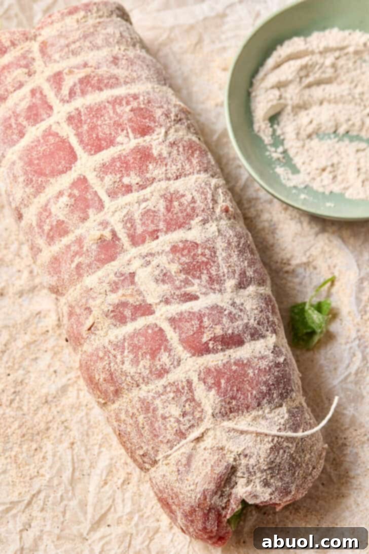 Rolled and stuffed flank steak, securely tied with kitchen twine and lightly coated with seasoned flour.