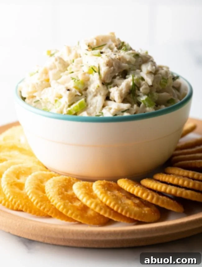 Bowl of real crab salad on top of a serving dish with crackers on it.
