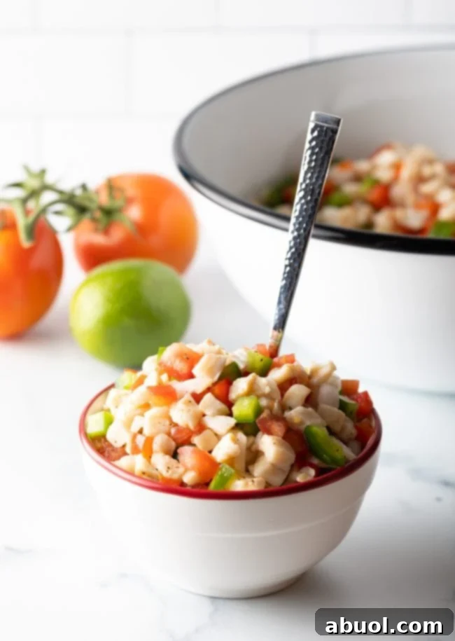 bowl of raw seafood salad with spoon, featuring fresh conch and vibrant vegetables