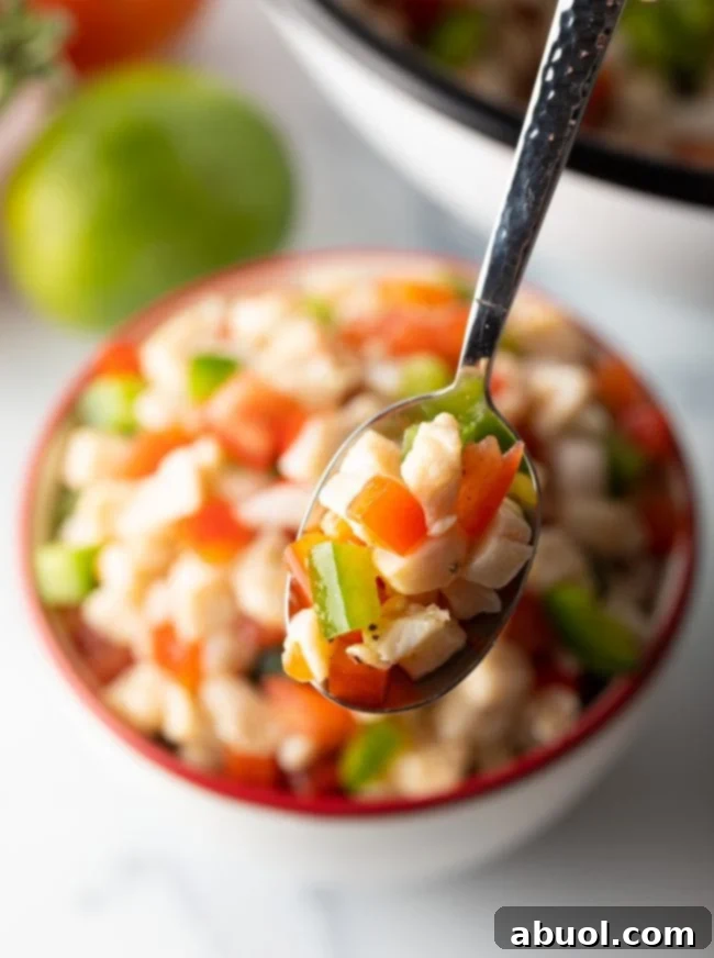spoonful of conch salad with peppers and tomatoes, highlighting the fresh ingredients