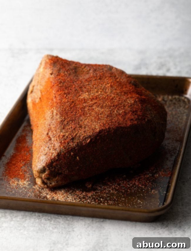 Oven-Baked Brisket Burnt Ends 5 Brisket Burnt Ends - Hunk of beef on a baking sheet covered with seasonings.