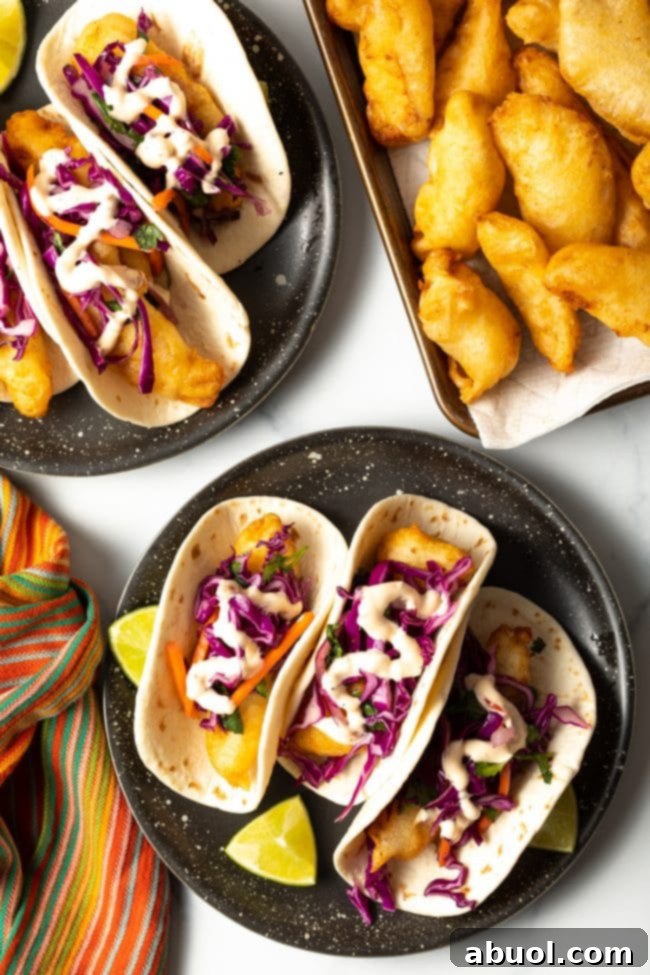 plates of fried fish baja tacos with shredded cabbage slaw and fish taco sauce