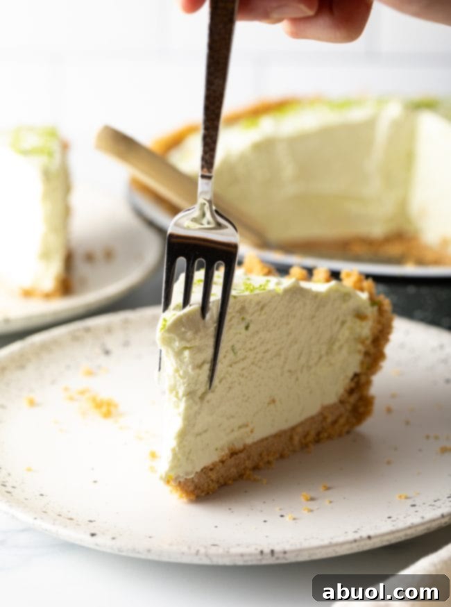 Slice of pie on a plate with a fork taking a bite out of it. 