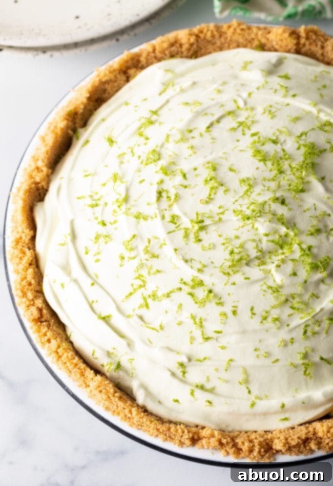 Full icebox pie with graham cracker crust and lime zest sprinkled on top.