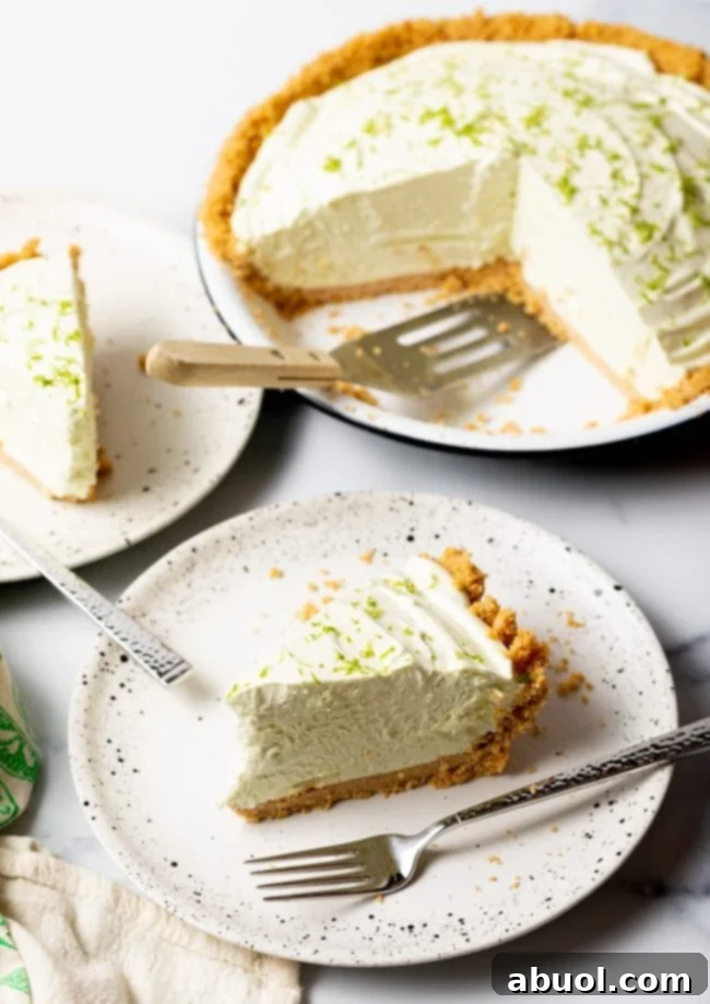 Slices of frozen key lime pie on plates with the full pie in the background
