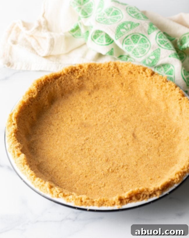 Pressed graham cracker crust mixture in a pie plate. 