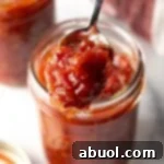 A small jar of homemade tomato jam, ready for serving or storage.