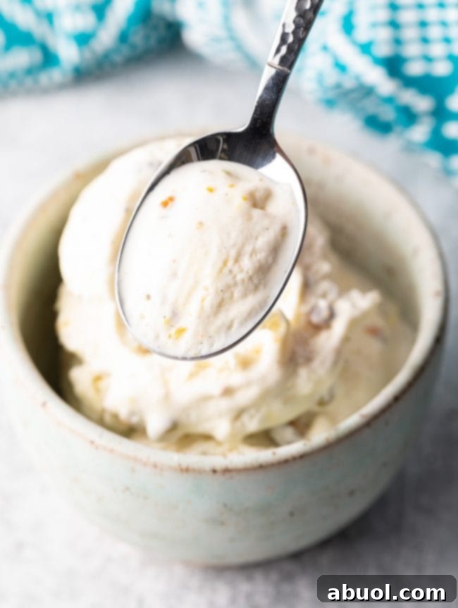 A perfect scoop of creamy saffron-infused Kulfi ice cream, garnished with pistachios, served in a bowl.
