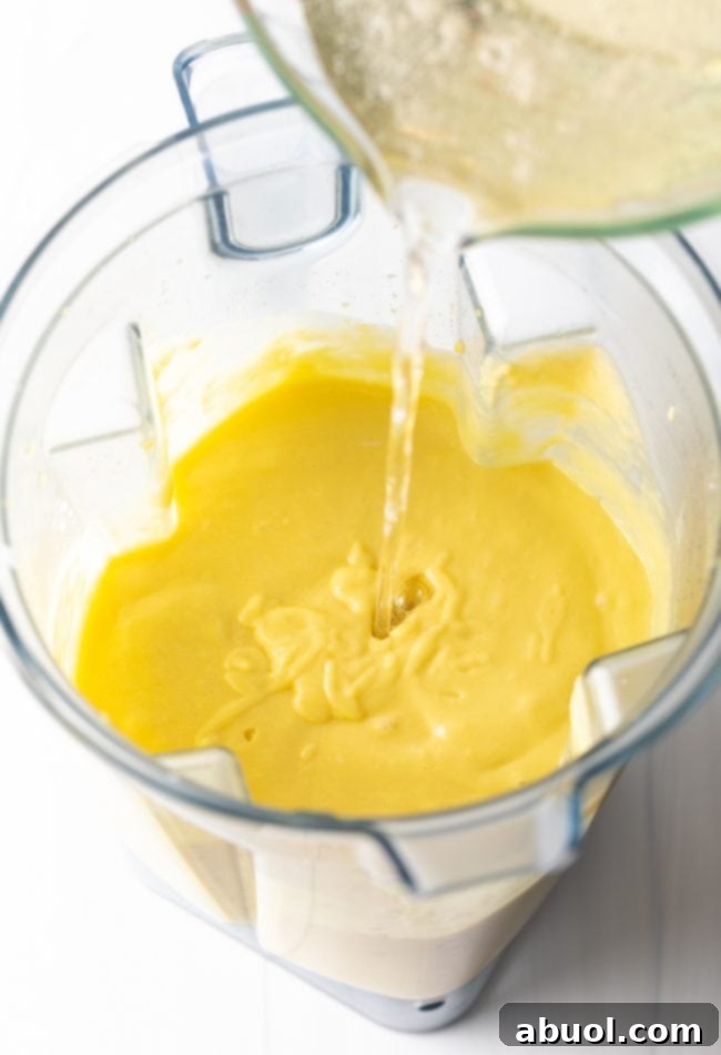 Step 5: Pouring the gelatin mixture into the blender with the mango and coconut milk.