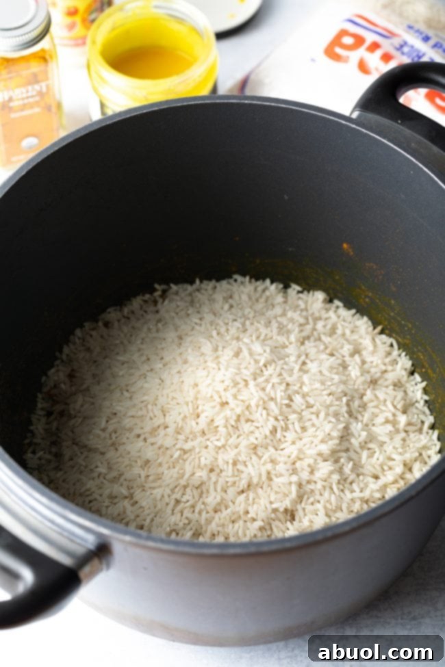 White rice added to sauteed veggies in pot. 