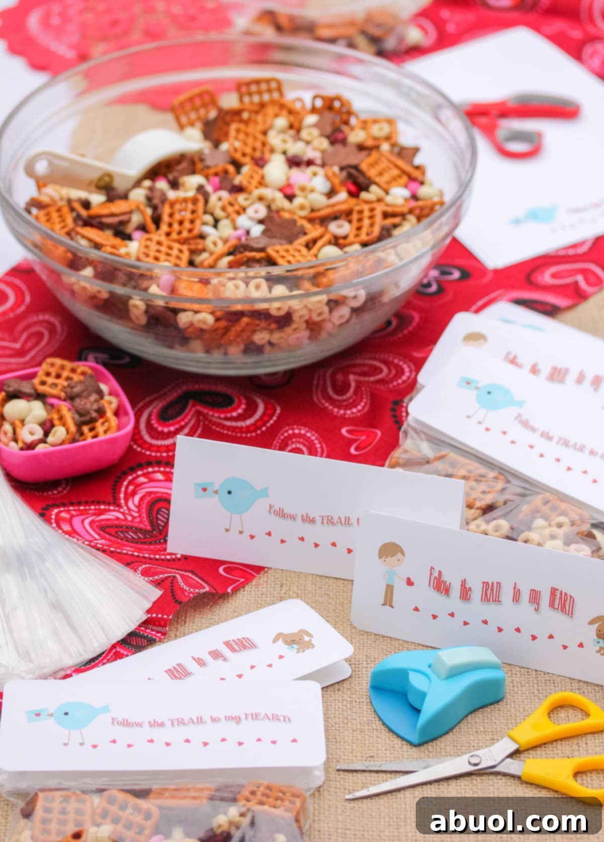 A large, inviting bowl of Valentine's Day trail mix, surrounded by smaller individual gift bags and charming printable tags, ready for sharing and gifting.