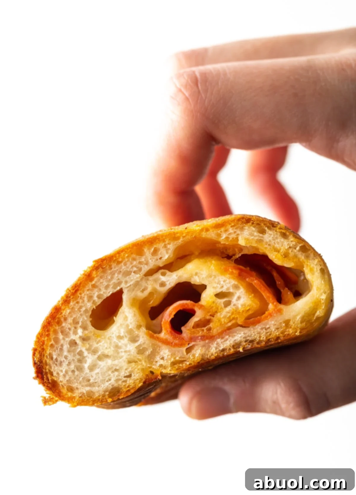 close up view of inside of pepperoni roll held by a hand
