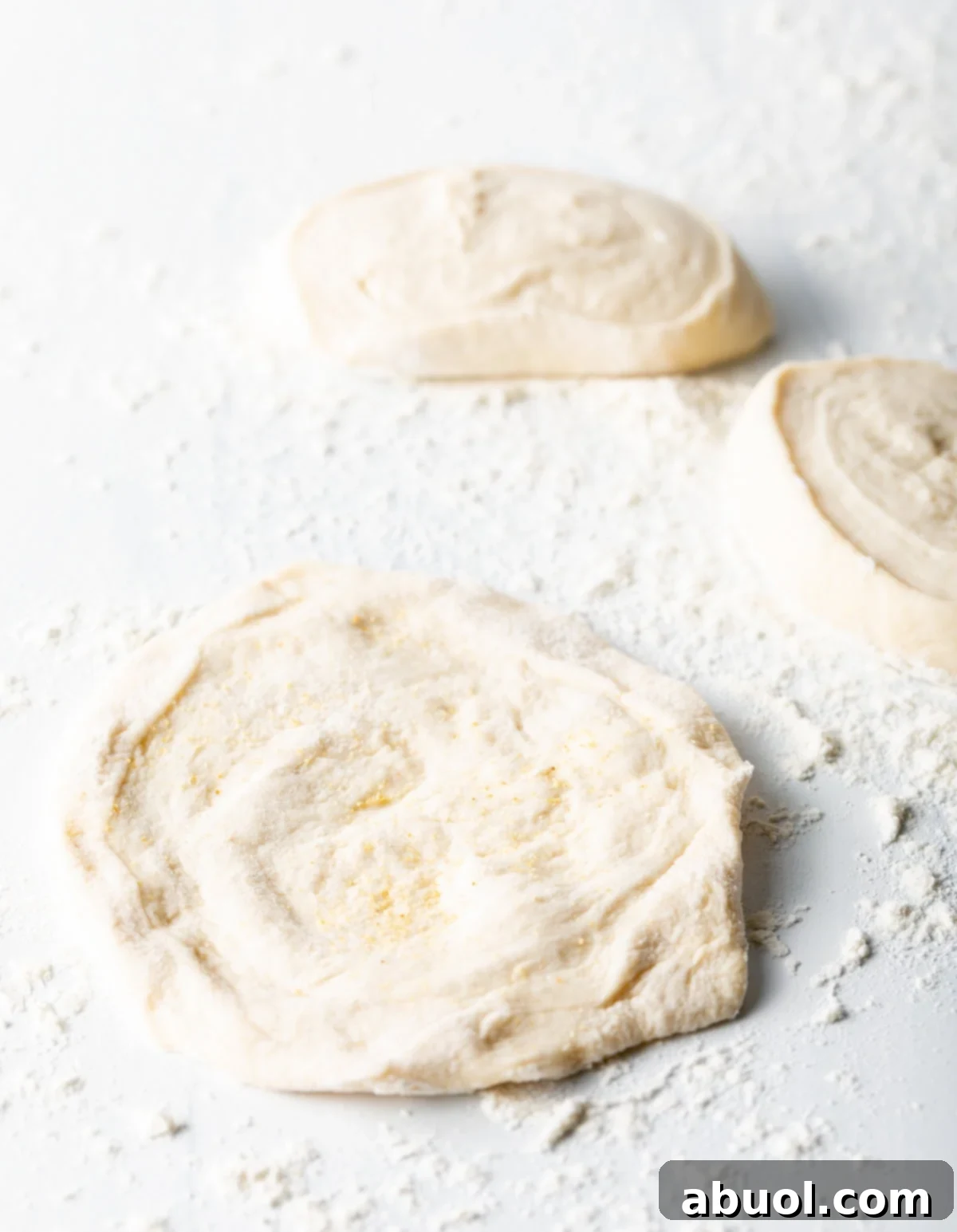 circles of dough stretched out on flour