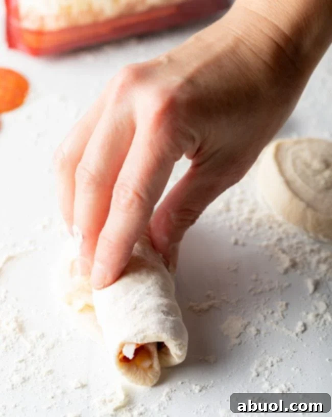 Hand rolling a pepperoni roll.