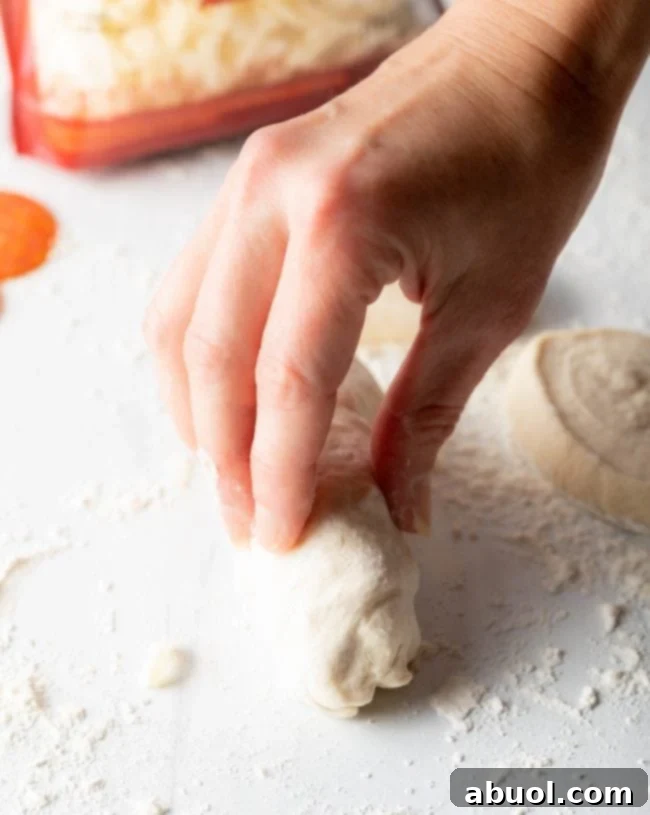 Hand rolling a pepperoni roll.