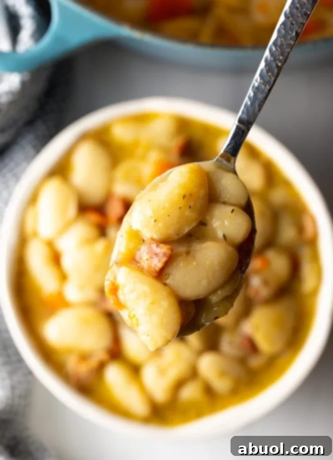 Final overhead view of butter beans recipe with bacon and veggies in a serving pot