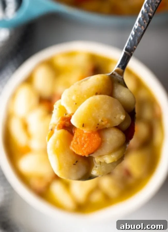Lima Bean Recipe - spoon scooping lima beans, carrots, and bacon