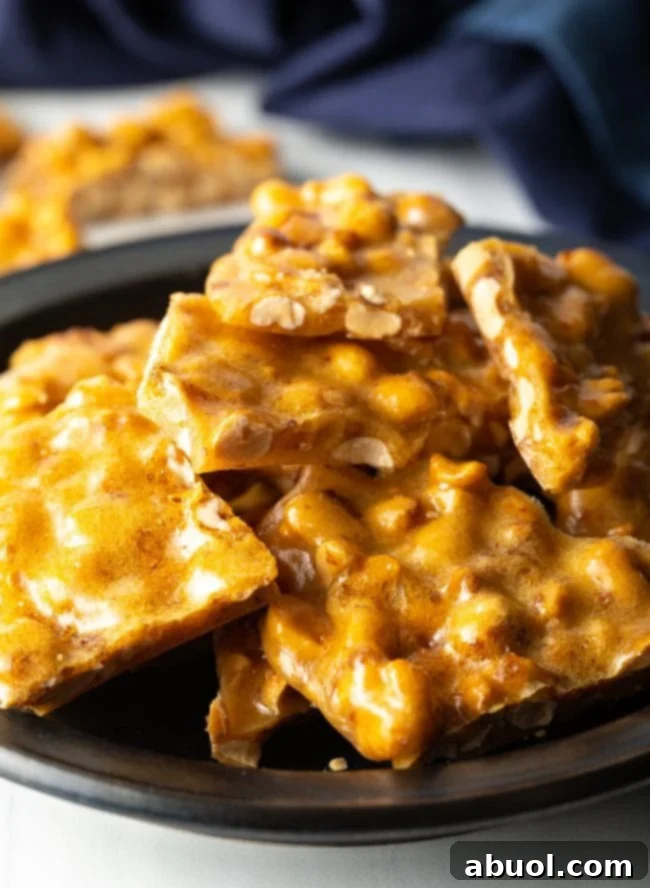close view of pieces of peanut brittle stacked on a black plate