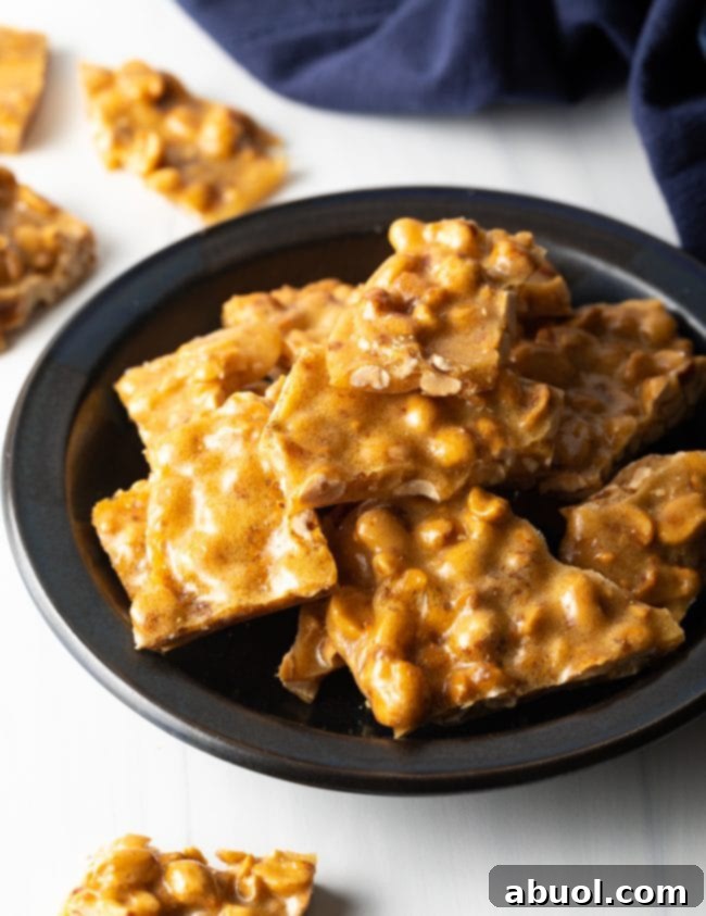 black plate loaded with shiny pieces of broken microwave peanut brittle