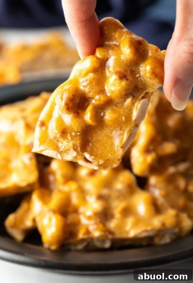 fingers holding piece of brittle up close to the camera