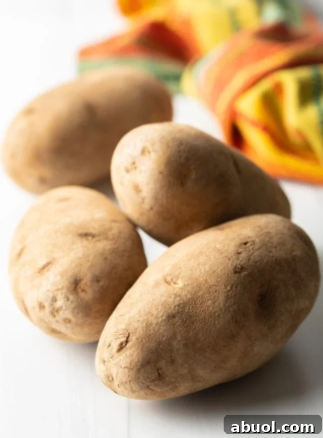 whole russet potatoes on a white background