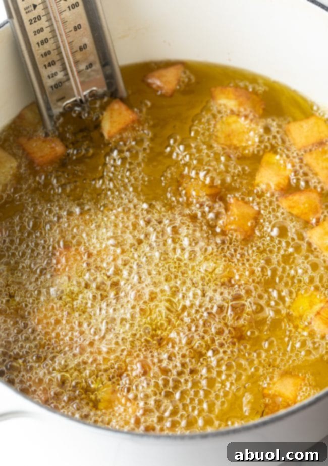 frying in hot oil in a large pot with thermometer clipped to the side