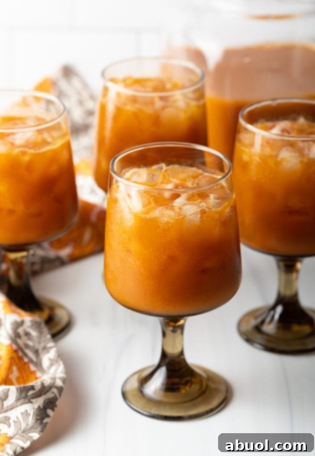 A charming cluster of goblets, elegantly filled with ice and the delightful Harry Potter copycat Pumpkin Juice, creating an inviting display.