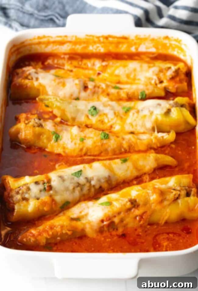 sausage stuffed banana peppers with marinara sauce in pan, ready to be served