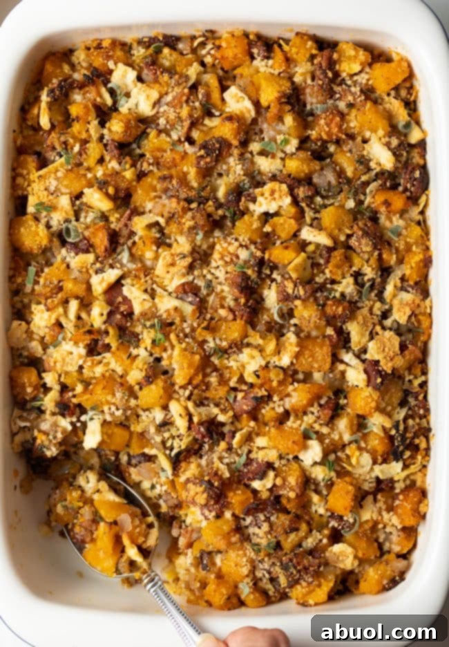 Butternut Squash Casserole - top view baked squash dressing with spoon scooping a portion