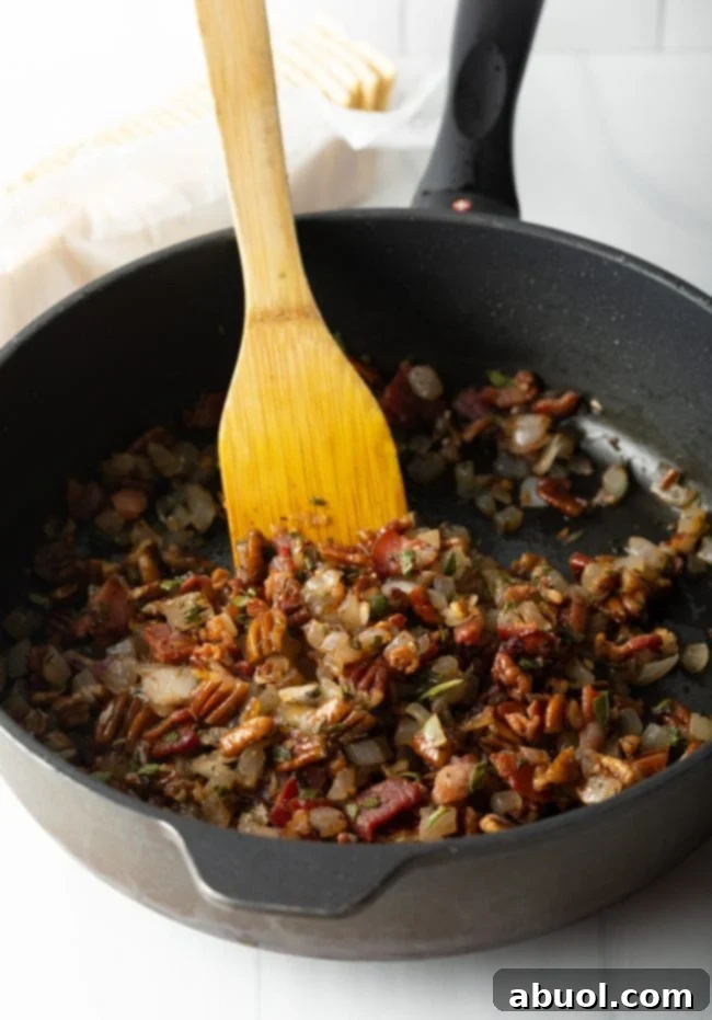 cooking bacon with aromatics in a cast iron skillet with wooden spoon