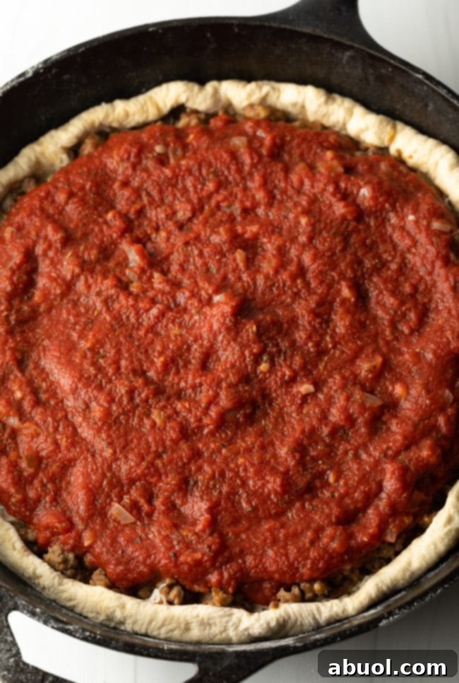 tomato sauce on top of the sausage and cheese