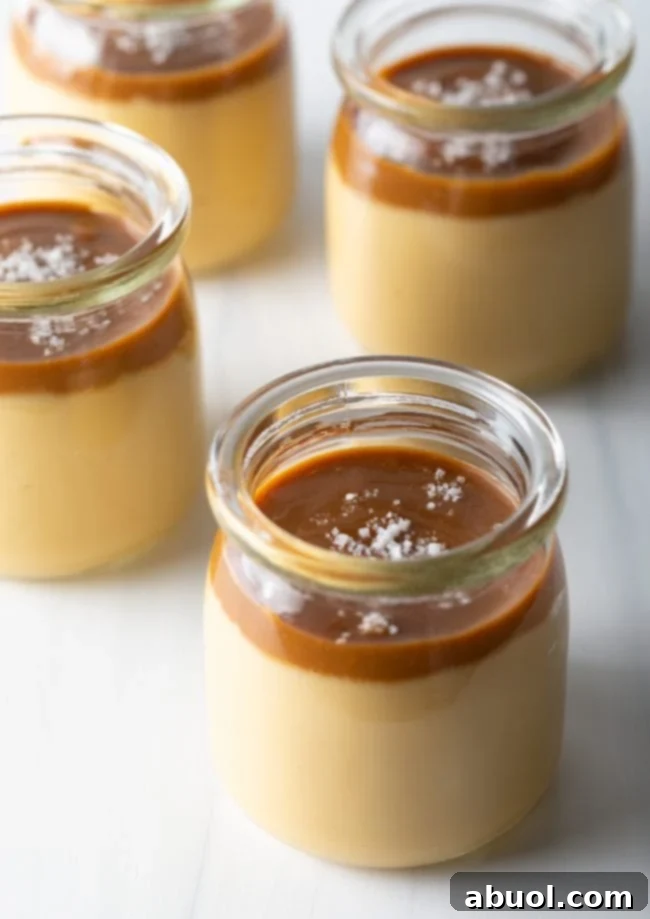 Jars filled with homemade butterscotch budino topped with salted caramel and sea salt