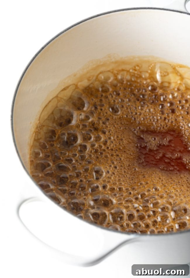 Large saucepan on the stovetop, with a rich brown sugar and water mixture simmering gently, showcasing its amber hue