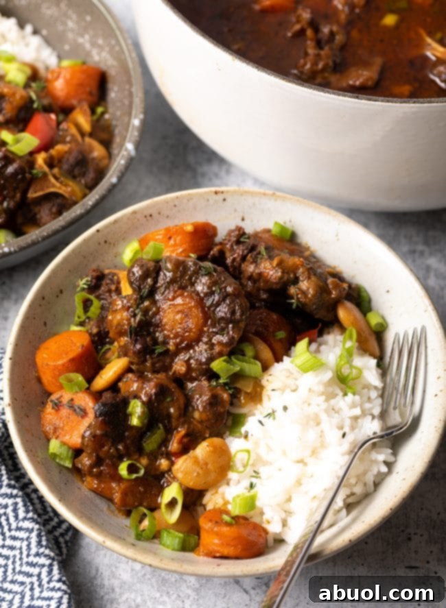 Jamaican oxtail stew recipe in a bowl with white rice.