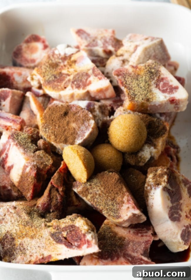 Uncooked oxtails topped with herbs. 