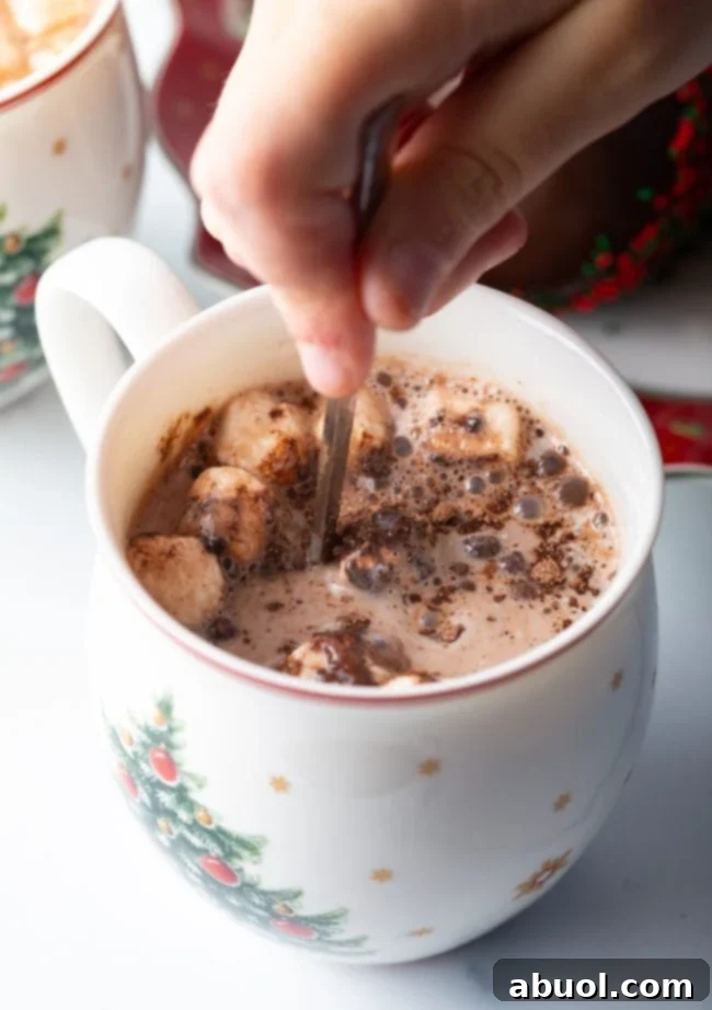 Velvet Cocoa Spheres 6 Hand mixing melted chocolate in mug.