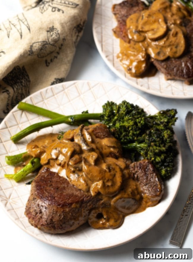 Cheesecake Factory's Iconic Steak Diane 10 Top view two white plates with copycat Cheesecake Factory steak Diane and broccolini. A full meal of Steak Diane.