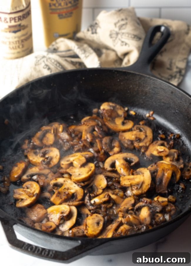 Cheesecake Factory's Iconic Steak Diane 6 Sliced mushrooms in a cast iron skillet. Preparing the mushroom sauce for Steak Diane.