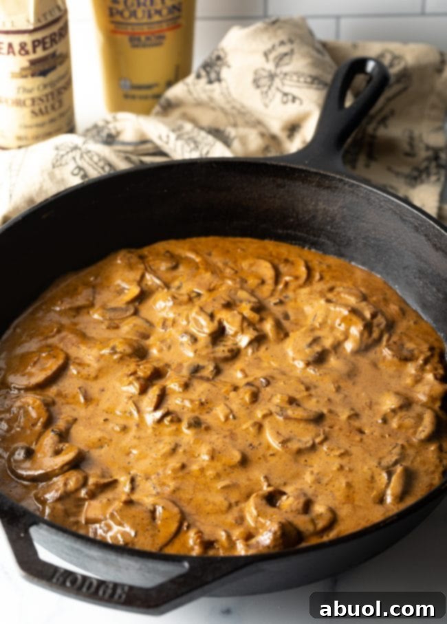 Cheesecake Factory's Iconic Steak Diane 7 Mushroom and cognac cream gravy in a cast iron skillet. The creamy sauce for Steak Diane.