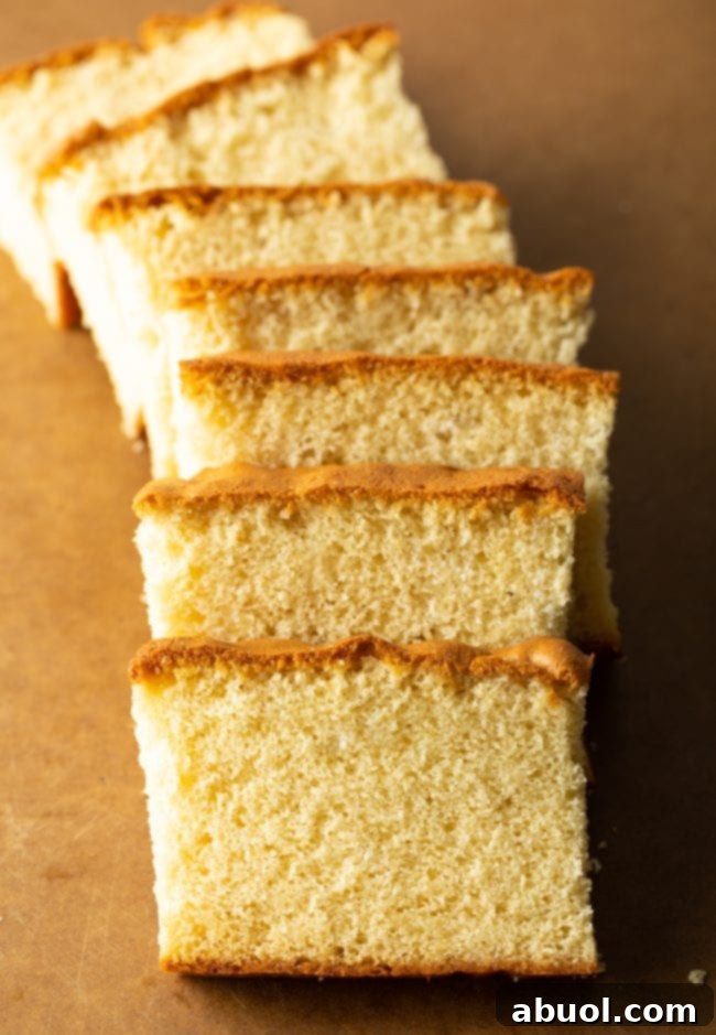 An inviting top-down view of perfectly sliced Japanese Castella cake on a brown cutting board, ready to be enjoyed.