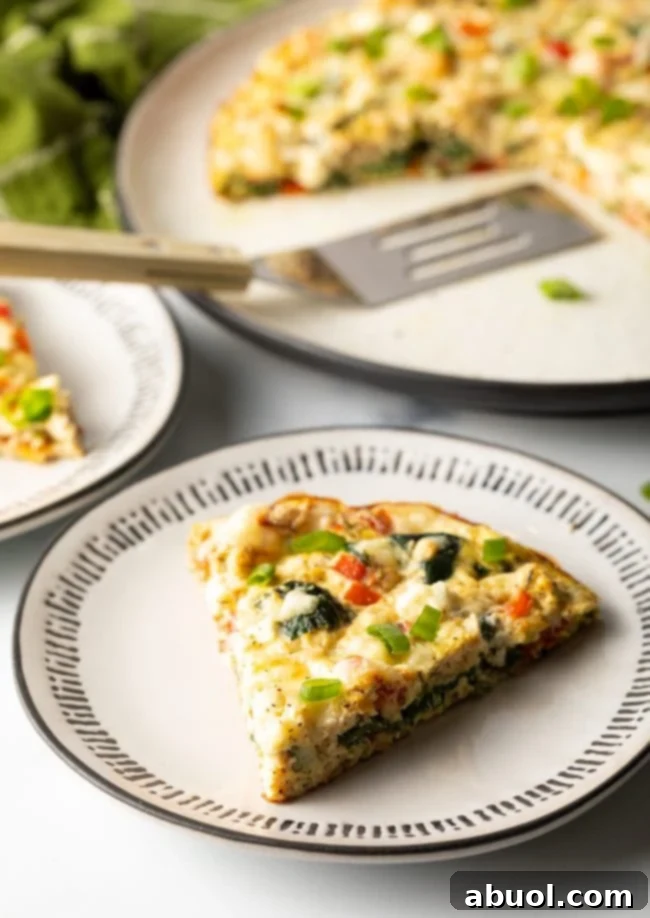 slice of egg white frittata on a plate with full baked dish in the background - a healthy, low-carb, high-protein meal.
