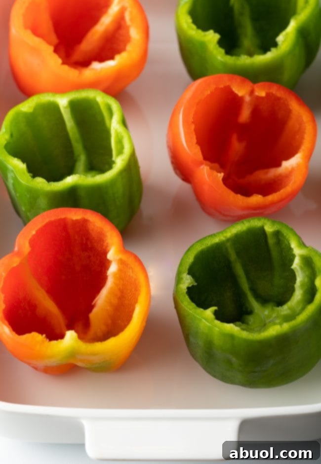 Empty seeded red and green bell peppers in a baking dish.