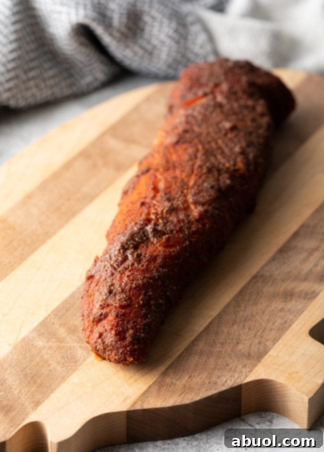 Ultimate Smoked Pork Loin Rub 8 whole smoked loin on a cutting board resting, covered loosely with foil