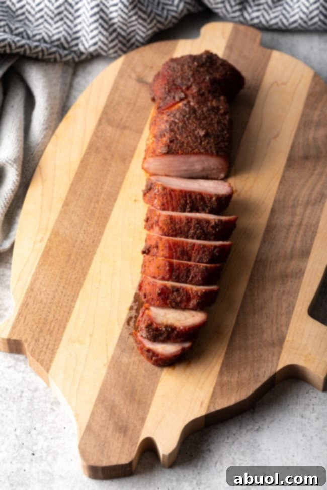 Ultimate Smoked Pork Loin Rub 10 top view of sliced pork tenderloin on a cutting board, highlighting its lean texture
