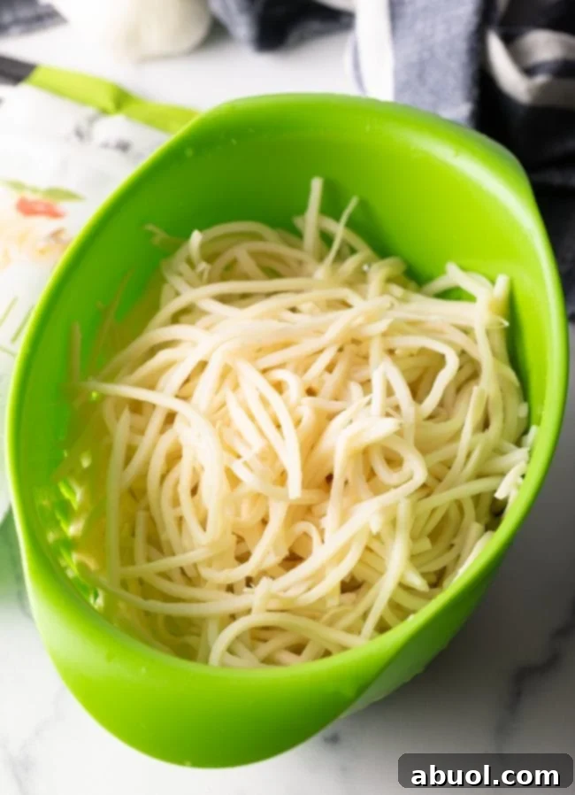 Drained hearts of palm noodles resting in a colander after rinsing, ready for the sauce.
