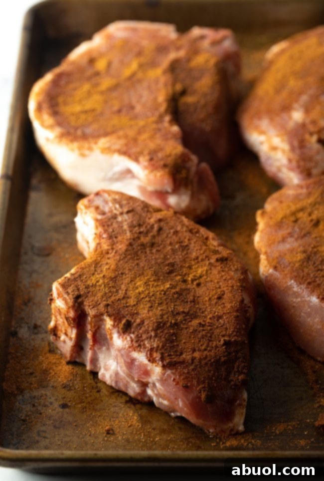 seasoned pork chops on a baking pan