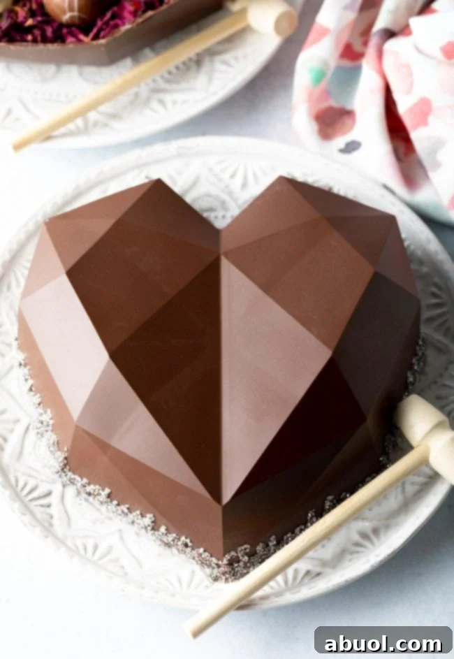 Exquisite breakable chocolate heart on a white plate, accompanied by a small wooden hammer, ready for a delightful smash, symbolizing a unique edible gift.
