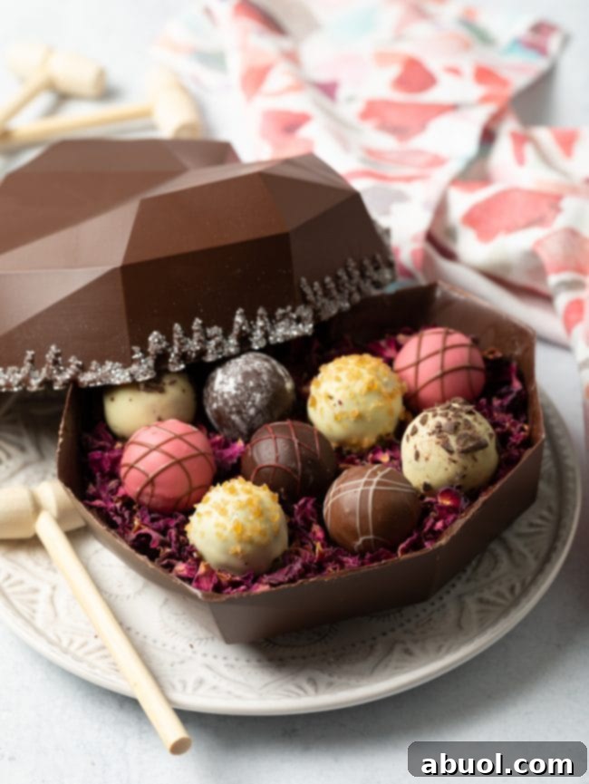 Side view of an inviting open bakery box showcasing a breakable chocolate shell generously filled with an assortment of gourmet truffles, ready to be enjoyed.