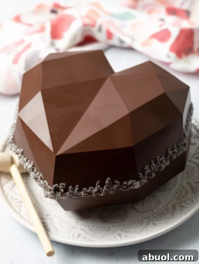 A beautifully decorated and sealed breakable chocolate heart gift box, shimmering with edible glitter around its middle, presented as a stunning sweet surprise.