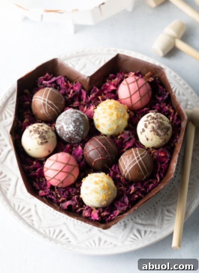 The alluring bottom half of a breakable chocolate heart, elegantly filled with delicate edible rose petals and a luxurious assortment of artisanal chocolate truffles.